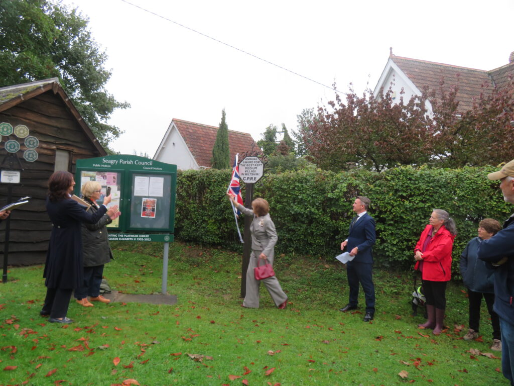 Mrs Sarah Troughton, Lord-Lieutenant of Wiltshire, unveils the Best Kept Medium Village shield at Seagry.